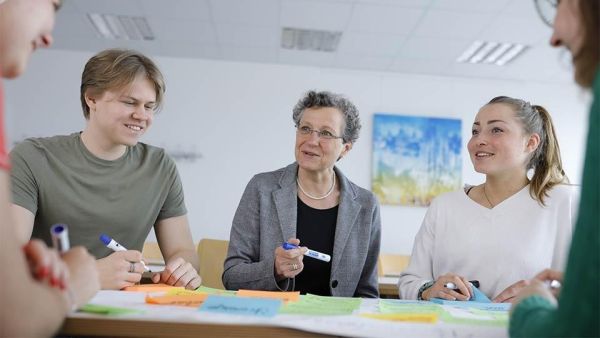 Master students discussing with professor at ISM in Berlin